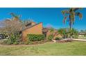The front exterior features a charming tan home with lush landscaping and mature palm trees at 1525 Hinton St, Port Charlotte, FL 33952