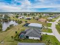 Expansive aerial view of neighborhood homes, ponds, and landscaped yards with screened-in pools in a lush community at 16265 Juarez Cir, Punta Gorda, FL 33955