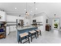 Modern kitchen featuring white cabinets, granite countertops, a stylish blue island with seating, and stainless steel appliances at 16265 Juarez Cir, Punta Gorda, FL 33955