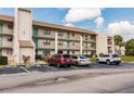 Condo building showcasing a well maintained green lawn and parking spaces at 175 Kings Hwy # 538, Punta Gorda, FL 33983