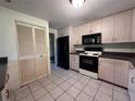 Functional kitchen features neutral cabinetry, black appliances, and easy-to-clean tile flooring at 20262 Hamilton Ave, Port Charlotte, FL 33952