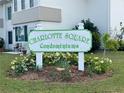 Entrance to Charlotte Square Condominiums with well-maintained landscaping and signage at 21287 Gertrude Ave # 106, Port Charlotte, FL 33952