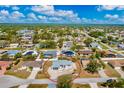 Overhead aerial perspective of a single-story house nestled in a tranquil residential area surrounded by trees at 21332 Walling Ct, Port Charlotte, FL 33954