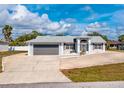 Front exterior view of a well-maintained, light-colored home with an attached garage and inviting entrance at 21332 Walling Ct, Port Charlotte, FL 33954