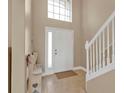 Bright foyer featuring neutral paint, tile flooring, and a staircase with white railings at 24528 Sunrise Dr, Punta Gorda, FL 33980