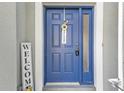 Charming blue front door with a welcoming wreath and a side window for added natural light at 24528 Sunrise Dr, Punta Gorda, FL 33980