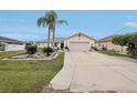 Welcoming single-story home featuring a two-car garage, a concrete driveway, and tropical landscaping at 5244 Early Ter, Port Charlotte, FL 33981