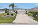 Inviting single-story home showcasing a two-car garage, long driveway, and neatly manicured landscaping at 5244 Early Ter, Port Charlotte, FL 33981