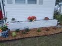 Close-up of beautiful landscaping including planter with bright flowers and decorative turtles at 5632 Holiday Park Blvd, North Port, FL 34287