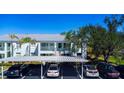 Exterior view of condo building with well-maintained landscaping and carport parking at 5725 Greenwood Ave # 3104, North Port, FL 34287