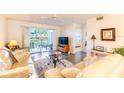 Bright living room with sliding glass doors to balcony and an adjacent view into the bedroom at 5725 Greenwood Ave # 3104, North Port, FL 34287