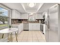 Bright kitchen featuring white cabinets, stainless steel appliances, and a stylish backsplash at 623 Oak Hill Cir # 28, Sarasota, FL 34232