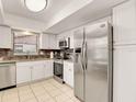 Well-lit kitchen features stainless steel appliances, white cabinetry, and tiled flooring at 623 Oak Hill Cir # 28, Sarasota, FL 34232