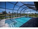 Relaxing pool with a view of the water, surrounded by a screened enclosure at 855 Rotonda Cir, Rotonda West, FL 33947