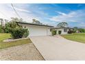 A single-story home with a long driveway leading to the attached two-car garage at 1052 Hinton St, Port Charlotte, FL 33952
