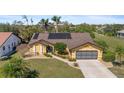 Attractive single-story home with a lush green lawn and mature landscaping with mature palm trees at 1225 Neapolitan Rd, Punta Gorda, FL 33983