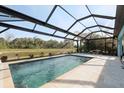 Stunning screened-in pool with travertine deck and beautiful views of the water and landscaping at 12285 Canavese Ln, Venice, FL 34293