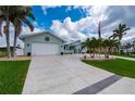 Exterior of single Gathering home with curved driveway, palms and nice landscaping at 1334 Via Milanese, Punta Gorda, FL 33950