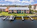 Waterfront condo with boat docks, manicured lawn, and views of the building's facade from the water at 1344 Rock Dove Ct # D102, Punta Gorda, FL 33950