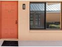 Welcoming front entrance with a vibrant coral door, sleek black window trim, and a 'welcome' mat at 1344 Rock Dove Ct # D102, Punta Gorda, FL 33950