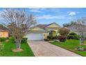 Beautiful home with a two-car garage, blue entry door, tile roof, and well-maintained lawn and landscaping at 1616 Palmetto Palm Way, North Port, FL 34288