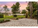 Beautiful backyard with a brick paved patio and lush landscaping with serene lake views at 17917 Wayside Bnd, Punta Gorda, FL 33982