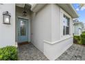Charming entrance with a blue glass paneled door, brick paved walkway, and decorative lighting at 17917 Wayside Bnd, Punta Gorda, FL 33982
