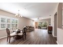 Open living and dining area with wood floors, chandelier, and sliding glass doors to a screened lanai at 2081 Willow Hammock Cir # F101, Punta Gorda, FL 33983