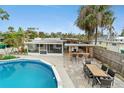 Relaxing backyard oasis with pool, screened patio, outdoor dining, and tropical landscaping at 23475 Harper Ave, Port Charlotte, FL 33980