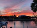 Waterfront homes showcasing a gorgeous fiery sunset, with boats docked along the canal at 611 Bal Harbor Blvd, Punta Gorda, FL 33950