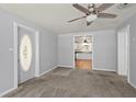 Bright living room with neutral walls, plush carpet, ceiling fan, and an inviting open floor plan at 8035 Hillman Ave, Punta Gorda, FL 33982