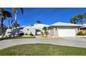 Charming single-story home showcasing a circular driveway, manicured lawn, and unique arched entrance at 931 Bal Harbor Blvd, Punta Gorda, FL 33950