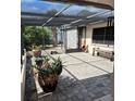 A patio with brick pavers, screening, a chiminea, and a bench offers outdoor living space at 22480 Oceanside Ave, Port Charlotte, FL 33952