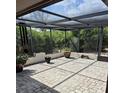 A screened-in patio featuring brick pavers and views of surrounding greenery at 22480 Oceanside Ave, Port Charlotte, FL 33952