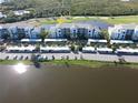 Overhead view of condo building, showcasing parking, nearby pond, and beautiful landscaping at 14081 Heritage Landing Blvd # 232, Punta Gorda, FL 33955