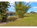 Spacious backyard with a screened-in pool and tropical landscaping at 1452 Wassail Ln, Punta Gorda, FL 33983