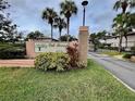 Oak Forrest Condominium entrance sign amid lush landscaping and palm trees for an over 55 community at 1515 Forrest Nelson Blvd # R201, Port Charlotte, FL 33952