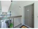 Hallway exterior showing a tan door numbered R-201 with railing and overhead lighting at 1515 Forrest Nelson Blvd # R201, Port Charlotte, FL 33952