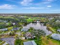 Aerial view of a charming home nestled by a serene lake and a lush green golf course in the distance at 3 Bermuda Cir # 49, Englewood, FL 34223