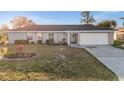 Charming single-story home featuring a well-maintained front yard and attached garage with a long driveway at 3265 Sunrise Trl, Port Charlotte, FL 33952