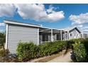 Charming home exterior with gray siding, screened patio, and lush landscaping at 3300 Loveland Blvd # 2103, Punta Gorda, FL 33980