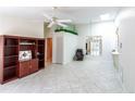 Bright living room with tiled floors, ceiling fan, and a view of the outdoor patio area at 3300 Loveland Blvd # 2103, Punta Gorda, FL 33980