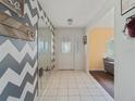Bright foyer with tile flooring and unique wall decor that creates a welcoming entrance at 4461 Baroda Ave, North Port, FL 34287