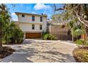 Rear exterior of house featuring a modern garage door and lush green landscape at 5239 Siesta Cove Dr, Sarasota, FL 34242