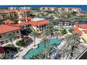 Aerial view showcases the community pool, lush landscaping, and Mediterranean-style architecture near the water at 85 Vivante Blvd # 8542, Punta Gorda, FL 33950