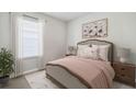 Serene bedroom featuring a large bed and floral artwork at 9519 Turtle Grass Cir, Punta Gorda, FL 33950