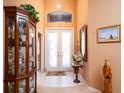 Inviting foyer with high ceilings, decorative glass doors, and a display cabinet for showcasing decor at 10488 Princess Ct, Punta Gorda, FL 33955