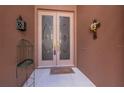 Elegant double front doors with decorative glass panels and neutral accents at 10488 Princess Ct, Punta Gorda, FL 33955