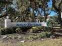 Well-maintained Bimini Bay Club community sign surrounded by lush landscaping and mature trees at 1051 Forrest Nelson Blvd # M 103, Port Charlotte, FL 33952