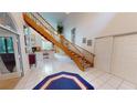 Bright entryway features white tile floors, a wooden staircase, and elegant decor at 1055 & 1075 Yorkshire St St, Port Charlotte, FL 33952